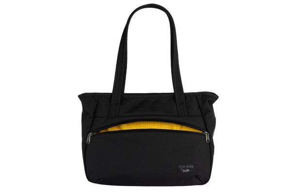 Photo of the Nomad Tote in Black Ballistic with Solaris (yellow with white grid) 200 Halcyon interior.